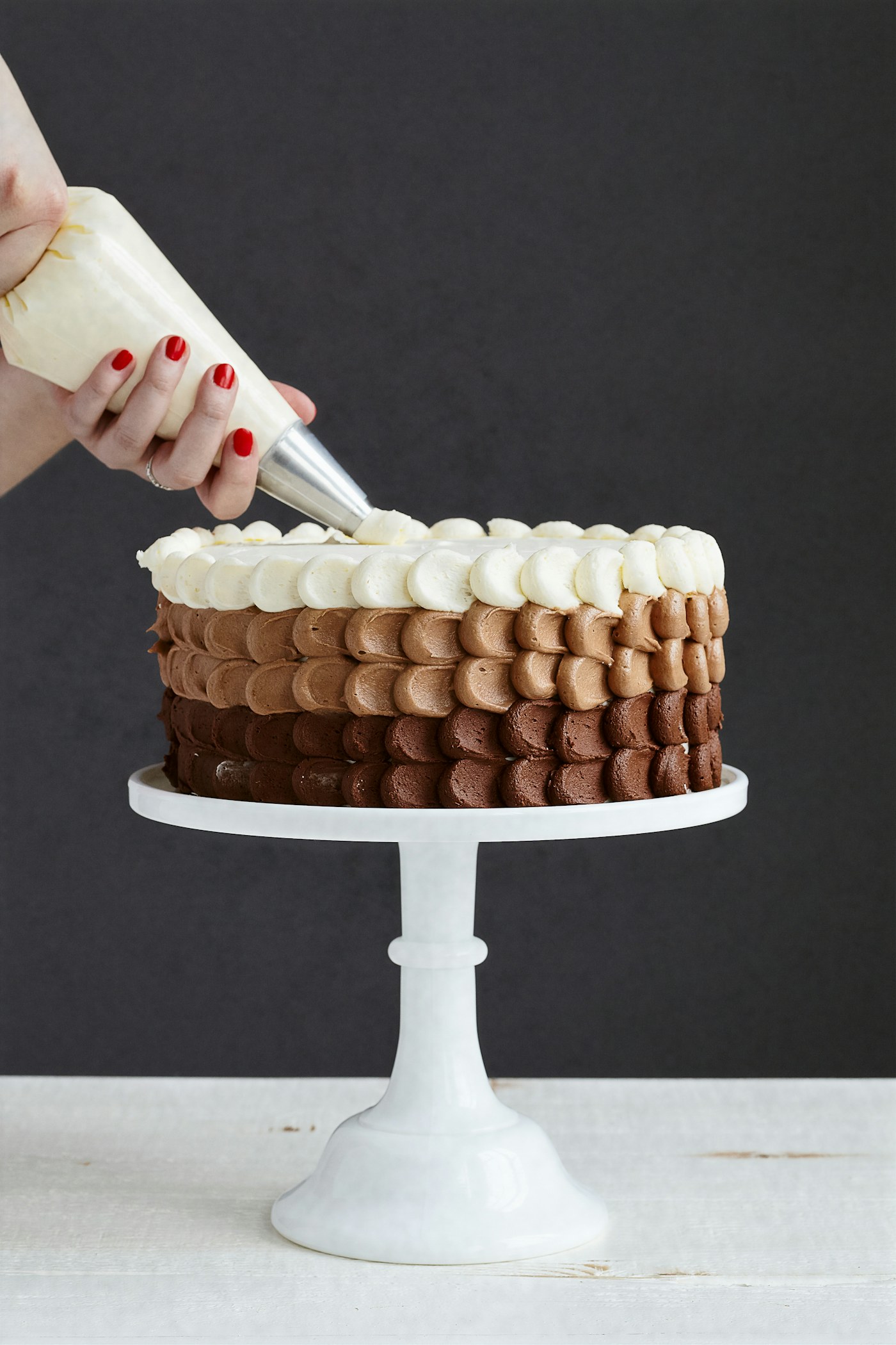 Baker carefully decorating a cake